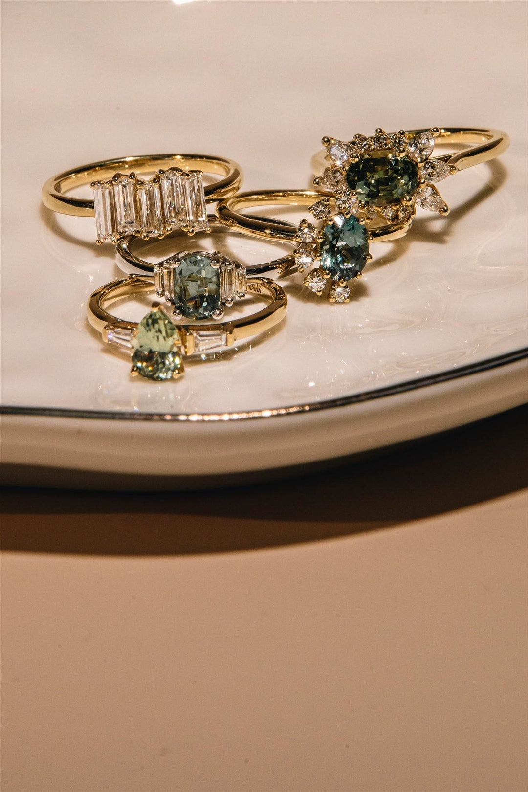 Montana sapphire rings in teal, sage green, and blue 14K gold