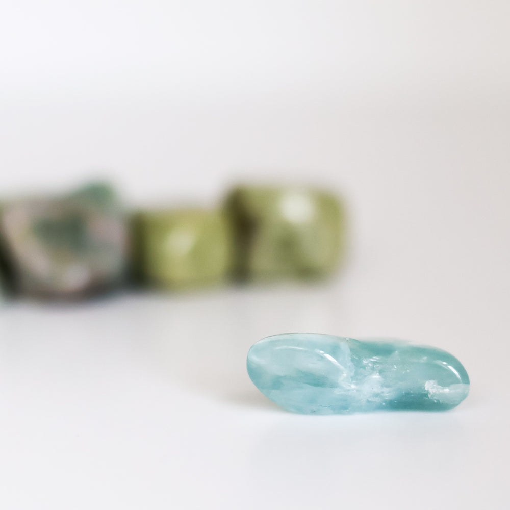 A collection of polished Aquamarine tumblestones on a light background.