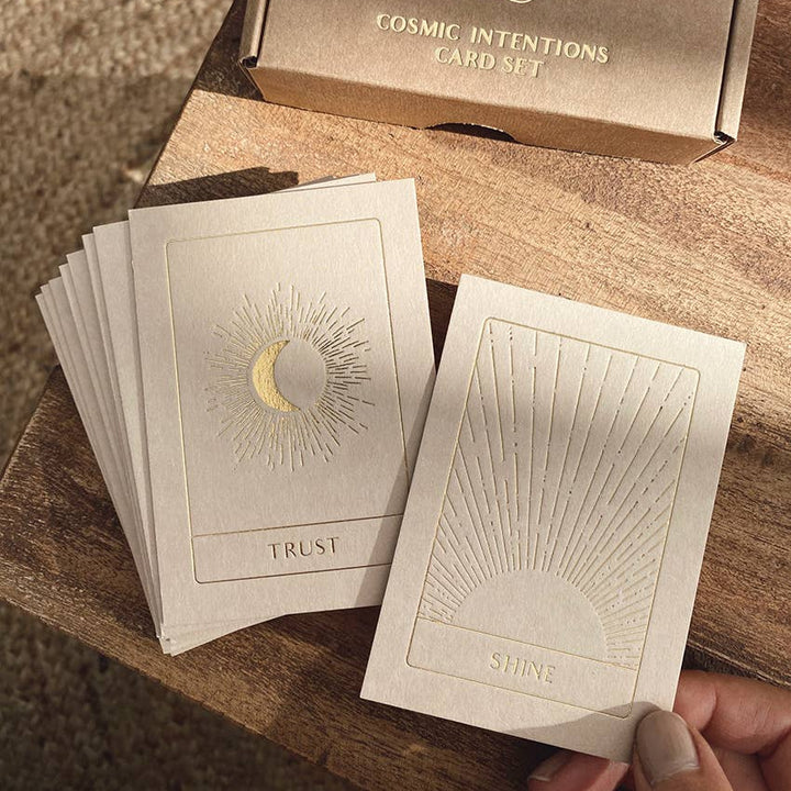 Cosmic Intentions card set with cards featuring 'Trust' and 'Shine' on a wooden surface.