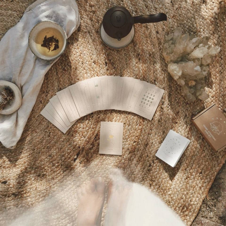 Tea-making setup with tea leaves, teapot, and packaging on a textured surface.