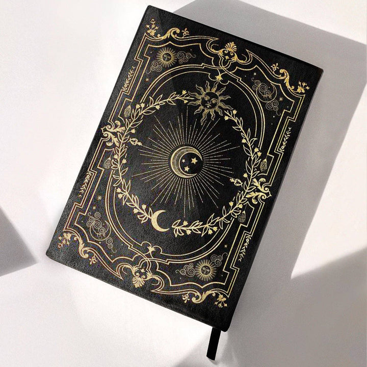 Black Dream ritual journal with gilded design on a white background