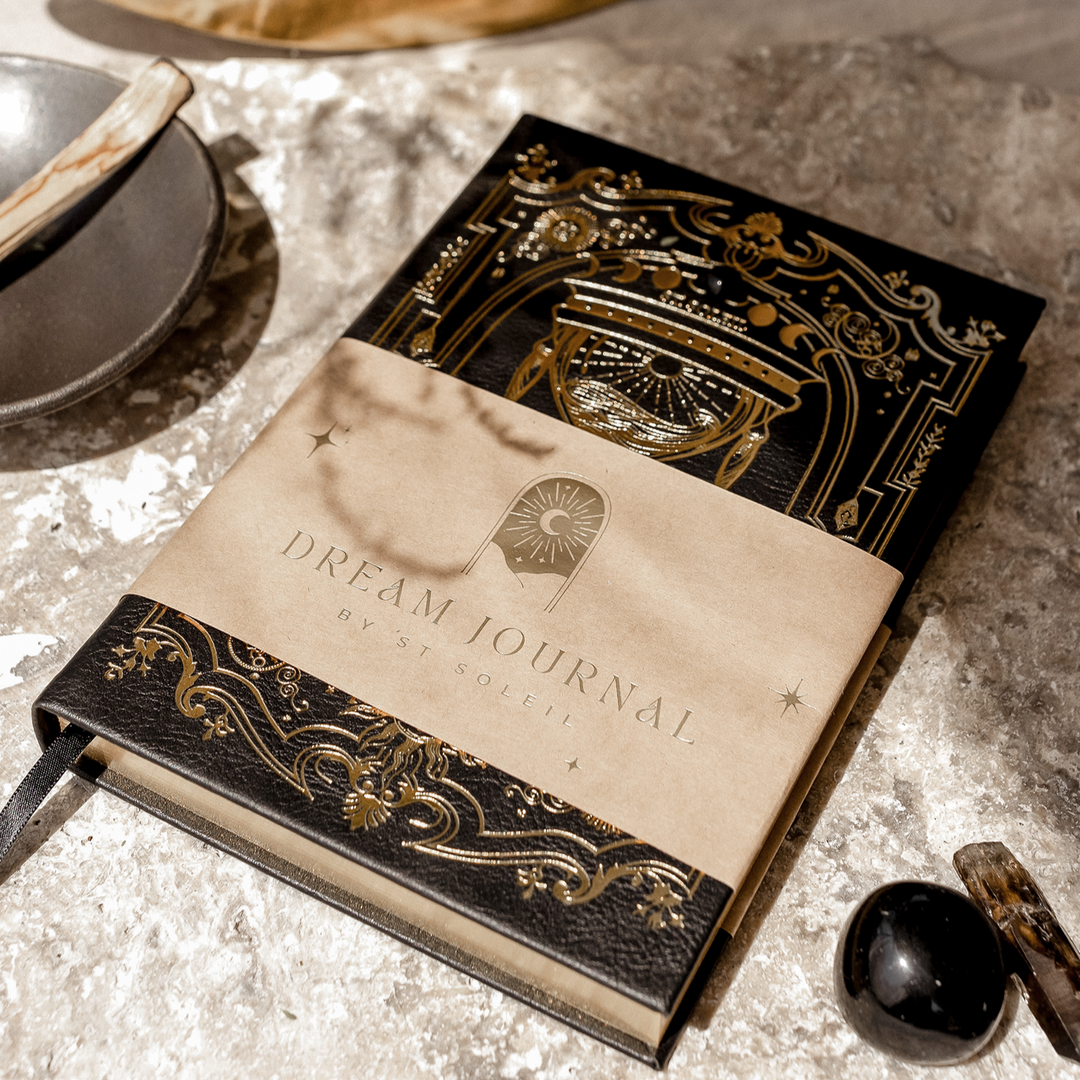 Decorative journal titled 'Dream Journal' with ornate cover on a textured surface.