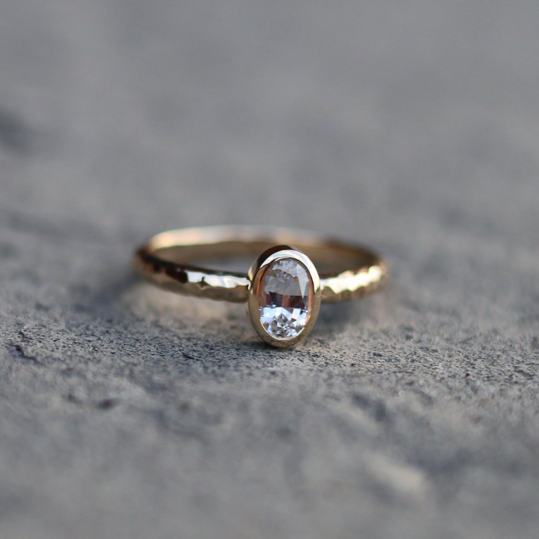 Gold ring with a gemstone on a textured gray surface