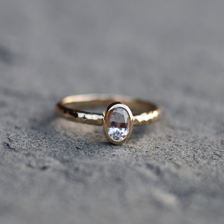 Gold ring with a gemstone on a textured gray surface