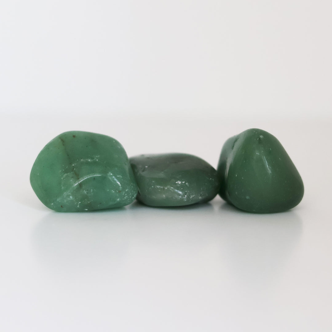Three polished Green Aventurine tumblestones arranged on a white surface.