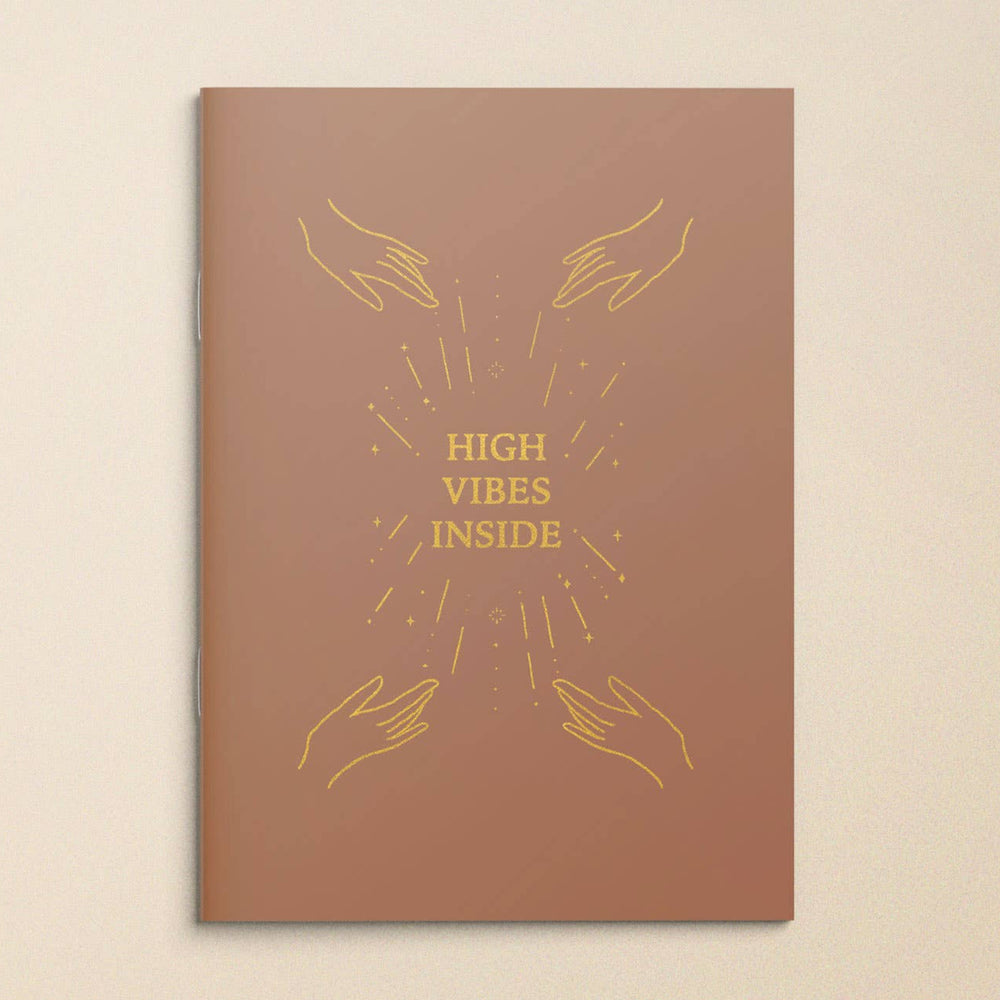 Brown book cover with gold text 'High Vibes Inside' and hand illustrations on a beige background