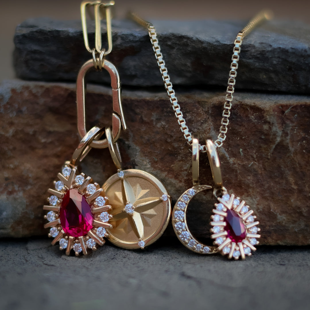 Gold jewelry set with pendants on a stone surface