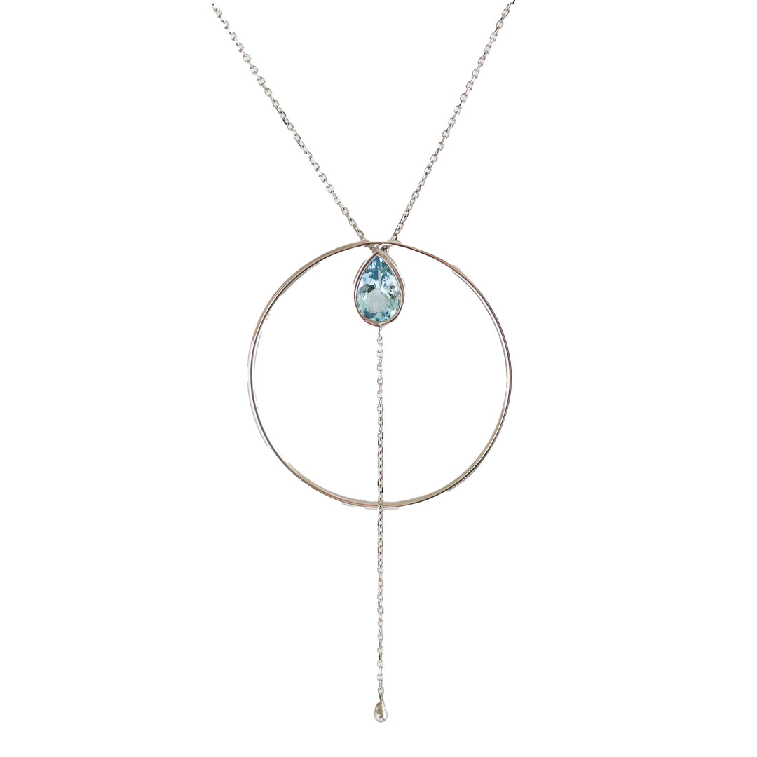 A Wayfinder Necklace with a white gold circle frame and a hanging aquamarine gemstone, suspended from a chain.