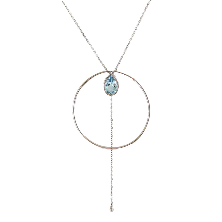 A Wayfinder Necklace with a white gold circle frame and a hanging aquamarine gemstone, suspended from a chain.