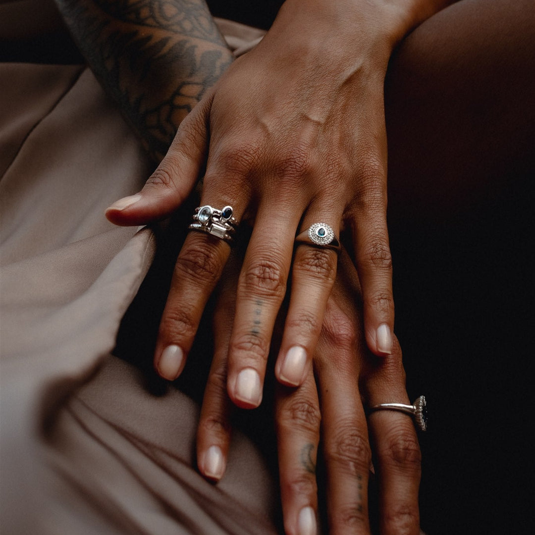 Close-up of hands with rings on a brown fabric background