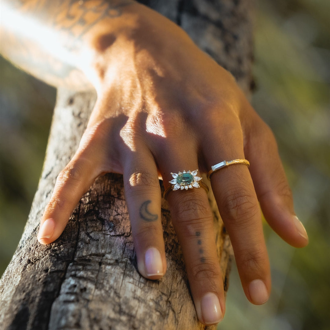 Hand with a ring on a tree trunk, sunlit background