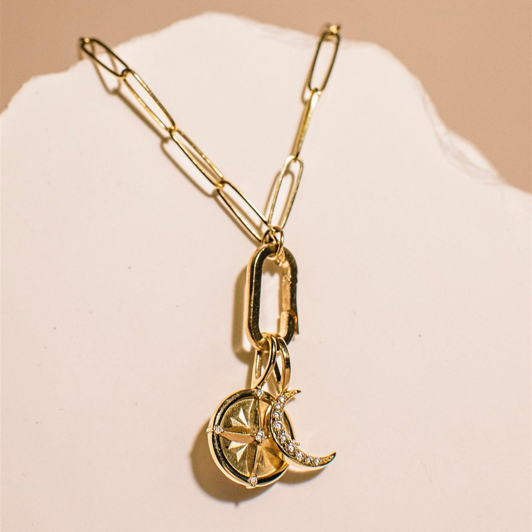 Gold bracelet with a unique pendant on a beige background
