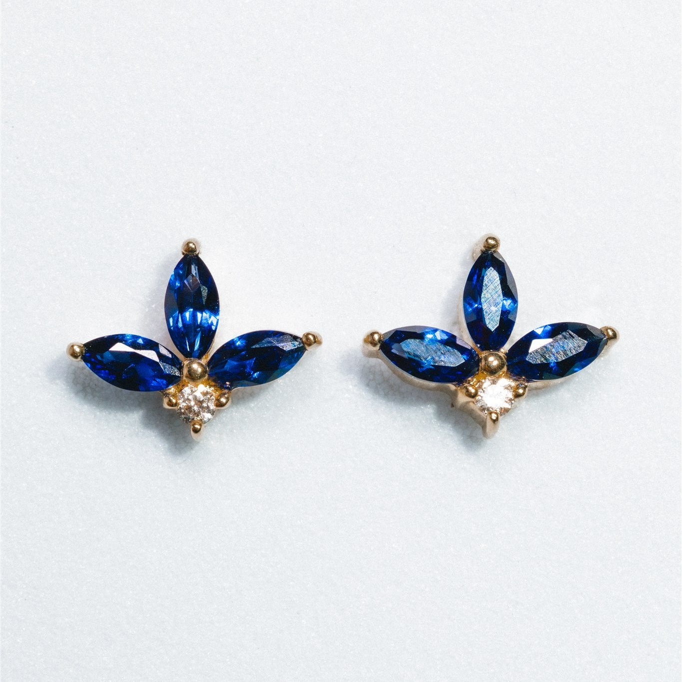 Pair of blue gemstone earrings on a light gray background