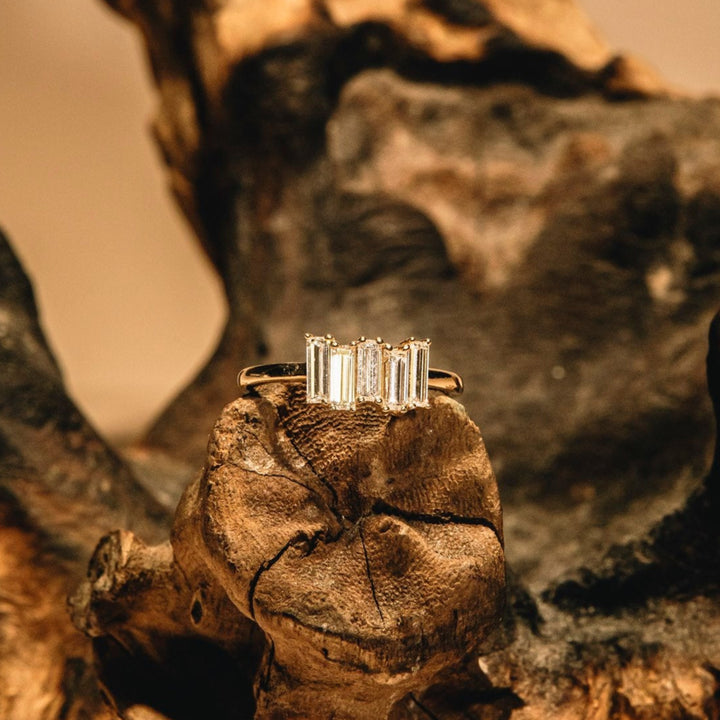 Gold ring with diamonds on a textured wooden surface