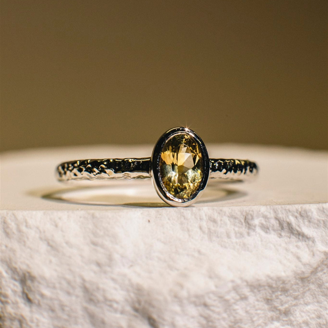 Ring with a yellow gemstone on a marble surface