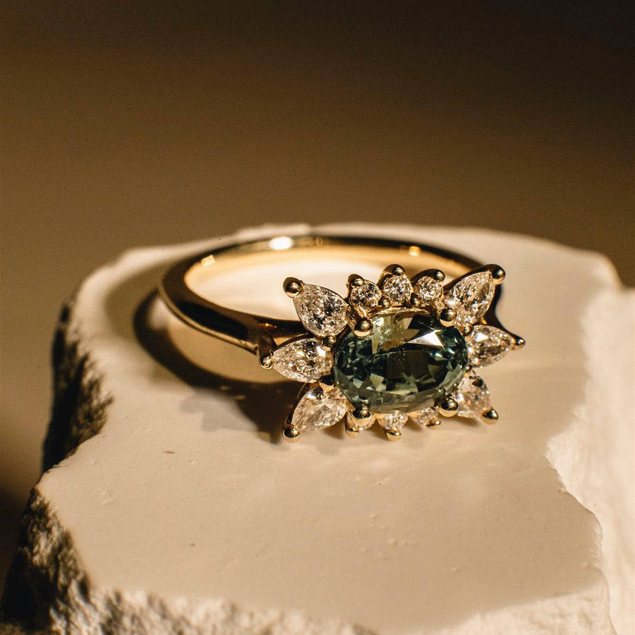 Gold ring with a green gemstone on a textured surface