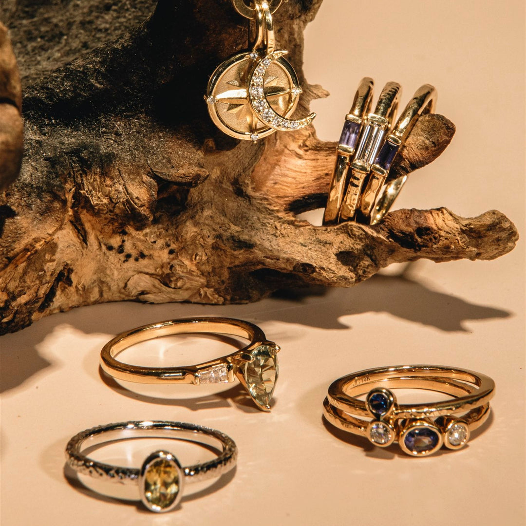 Gold rings with gemstones on a wooden surface