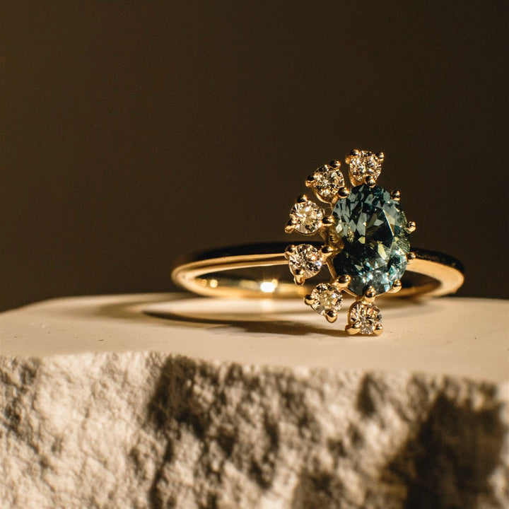 Gold ring with gemstones on a textured surface