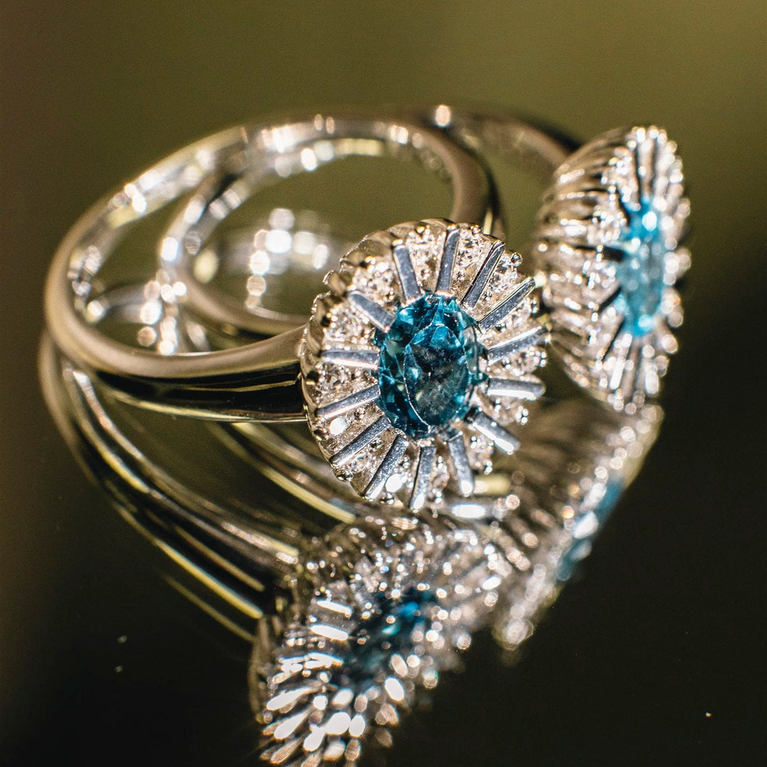 Silver ring with blue gemstones on a dark background