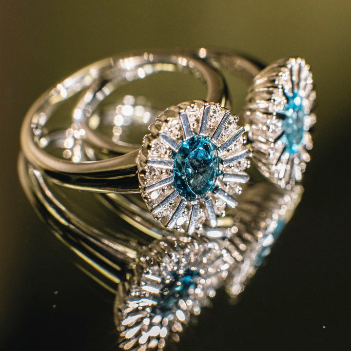 Silver ring with blue gemstones on a dark background