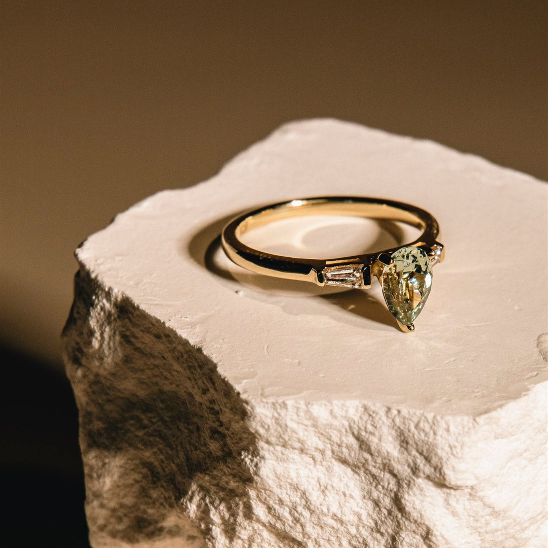 Gold ring with a diamond on a textured stone surface