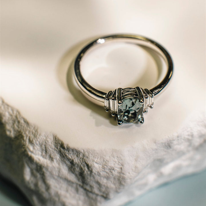 Silver ring with a diamond on a textured surface