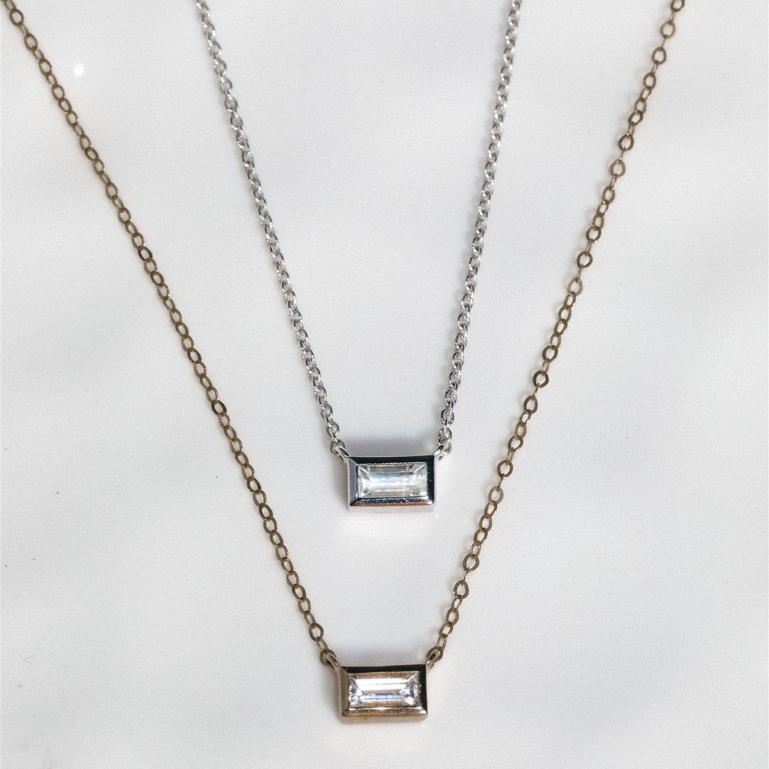 Two necklaces with rectangular pendants on a white background