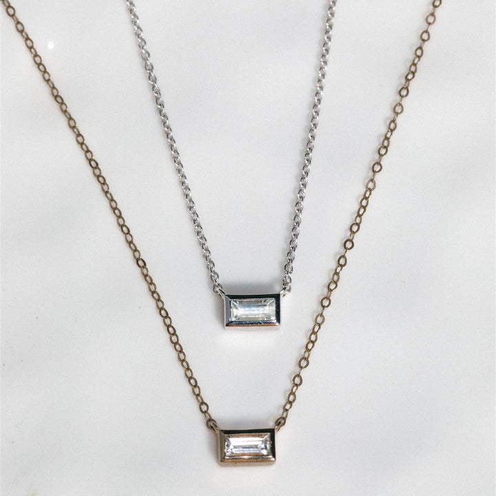 Two necklaces with rectangular pendants on a white background