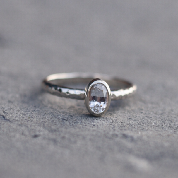 silver oval stacking ring on a textured gray surface