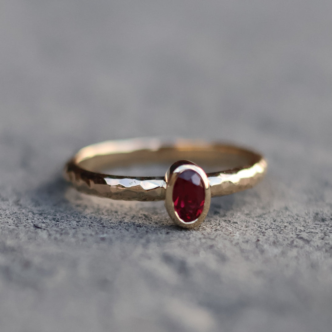 gold ring with ruby on a textured gray background