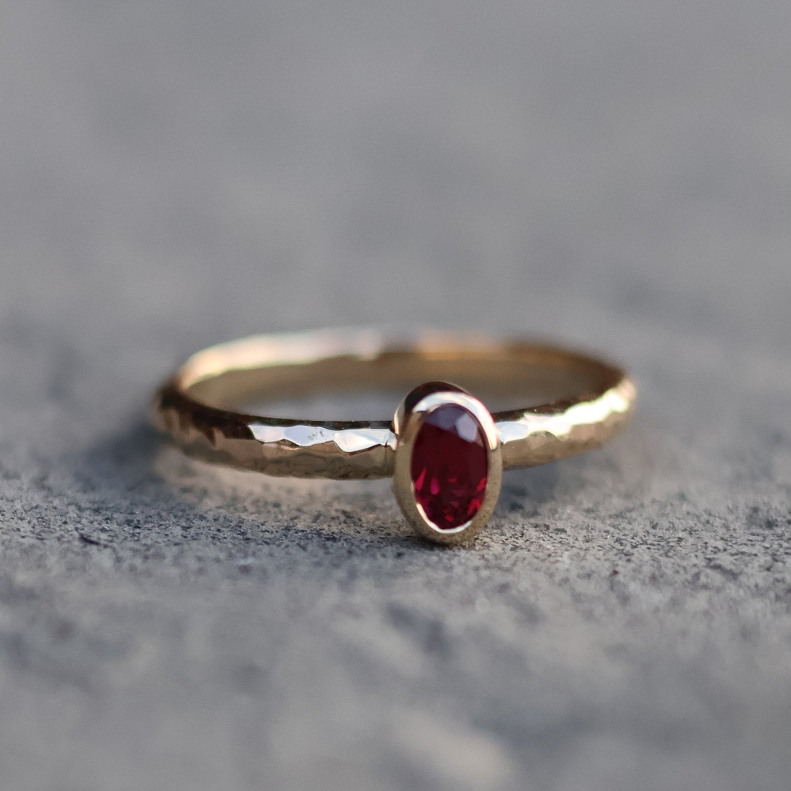 gold ring with ruby on a textured gray background