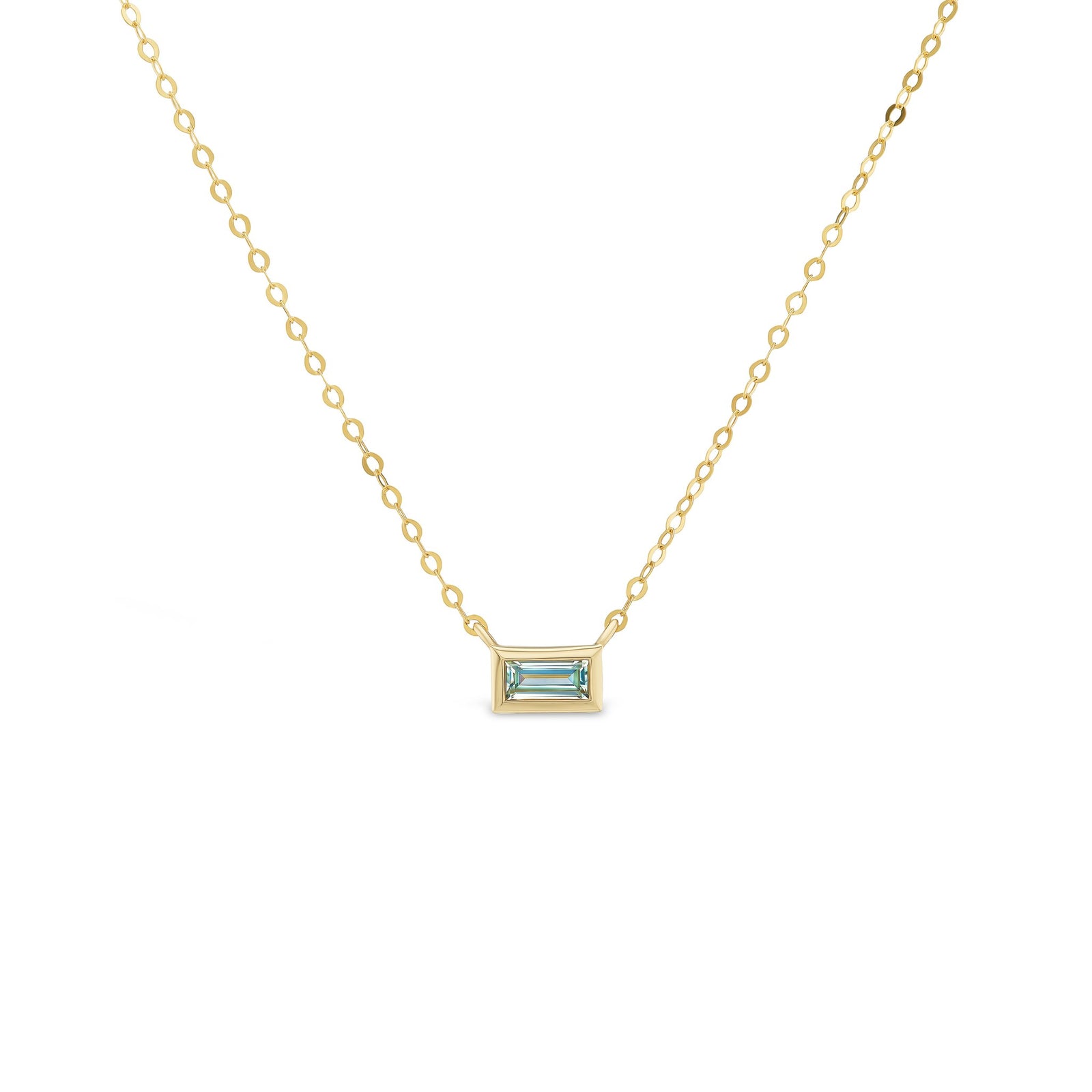 Gold necklace with a rectangular gemstone pendant on a white background