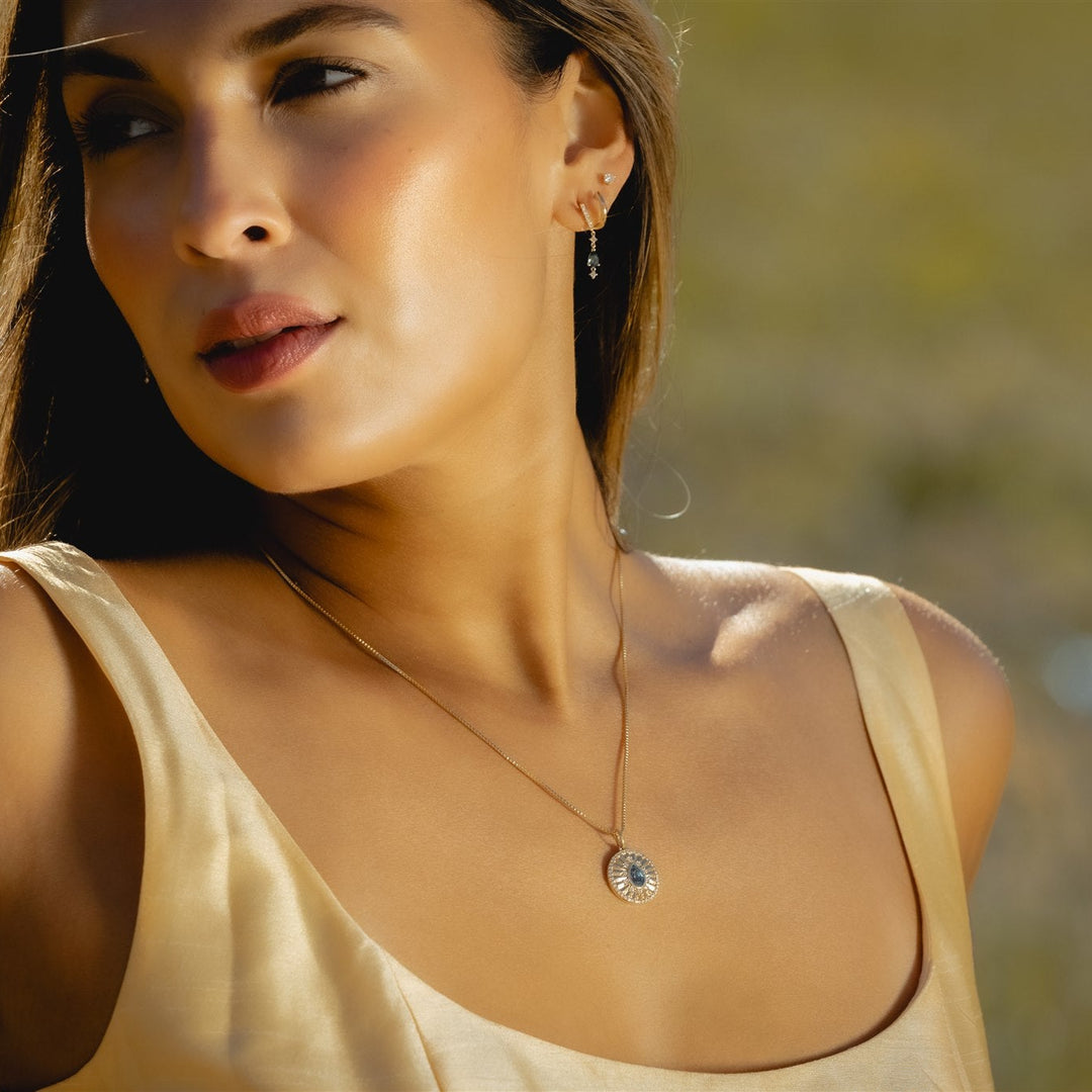 Talismania drop earrings in solid 14K gold worn outdoors — Talismania