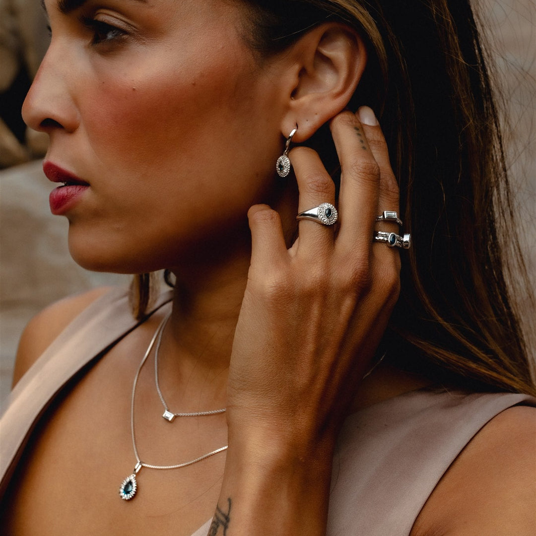 Headwaters pendant in solid 14K yellow gold with a Montana sapphire, worn with other Talismania pieces — Talismania